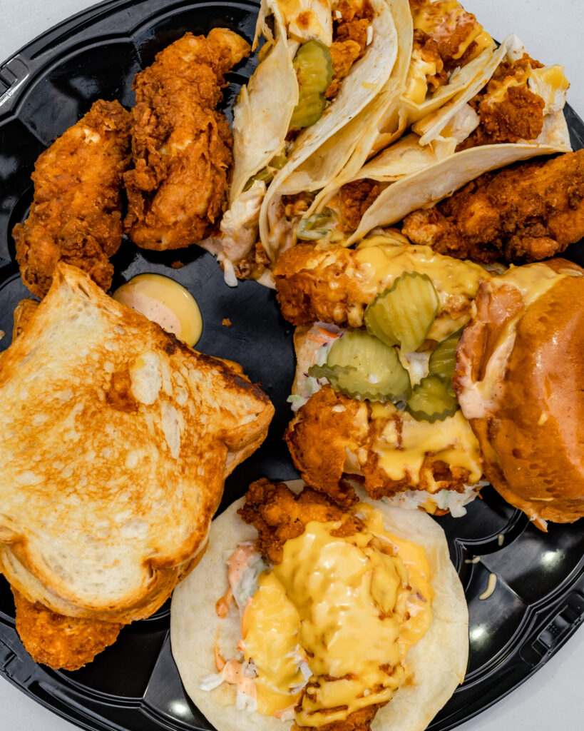 Nashville Hot Chicken Platter With Tacos, Tenders, Sliders, And Sandwiches At Clutch City Cluckers - Tomball Tx